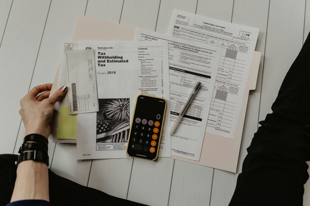 Working through costs with a calculator, a phone and printed paperwork