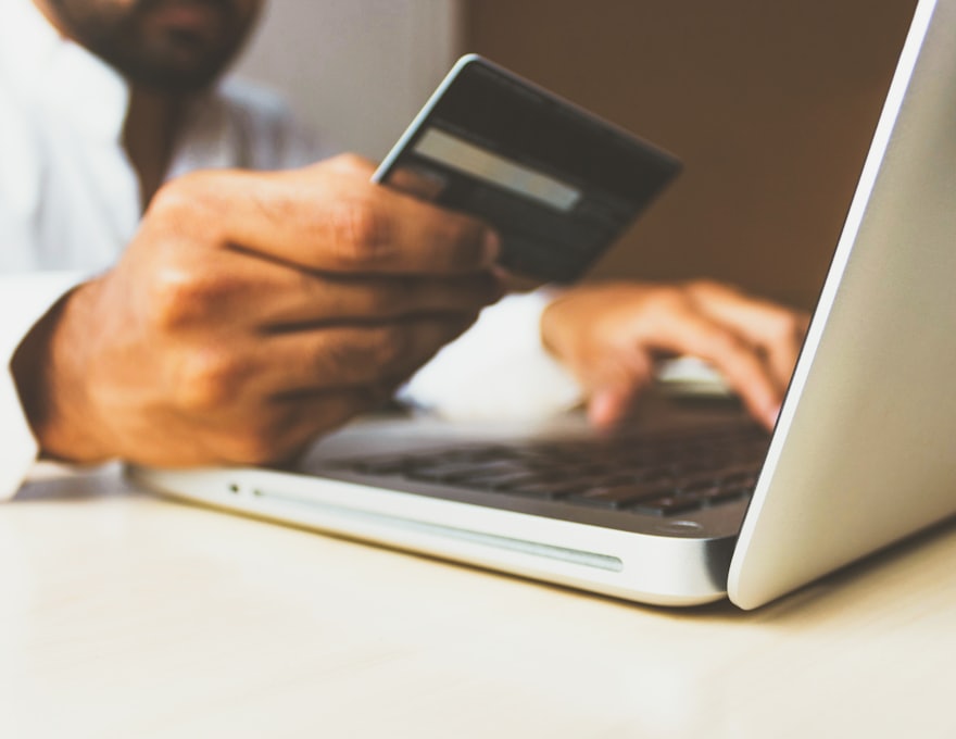 A customer entering card details at a laptop to complete an online order