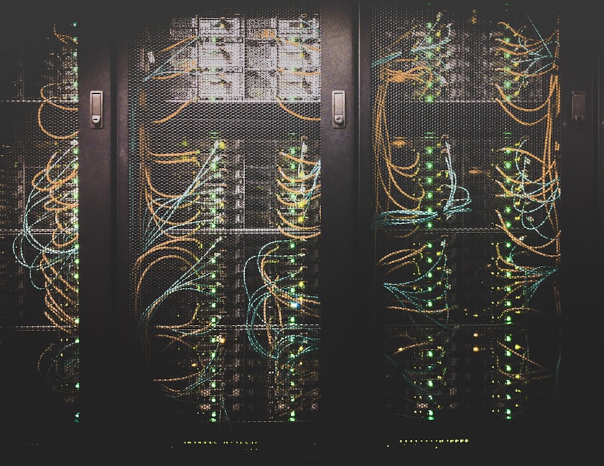 Rows of server racks in a data centre, lit along the cable runs