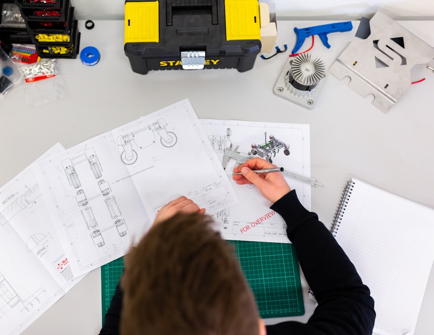 A workbench with tools and technical drawings laid out for scheduled upkeep
