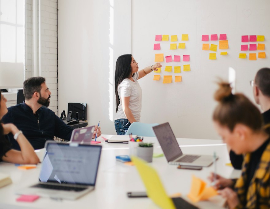 A team mapping out a structure on a wall of sticky notes during a planning session