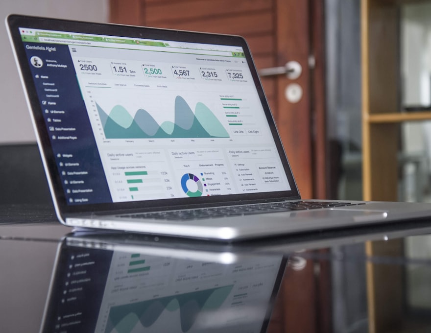 A reporting dashboard open on a laptop, charts and figures on one screen